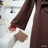Long brown crossover coat with buttons.